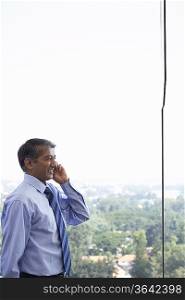 Business man using cell phone, smiling, side view