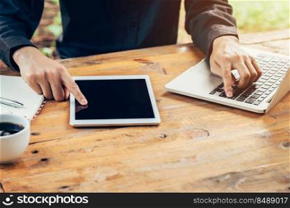 Business man using tablet on wood table in coffee shop.