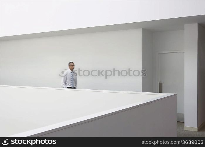 Business man walking through office hallway, side view