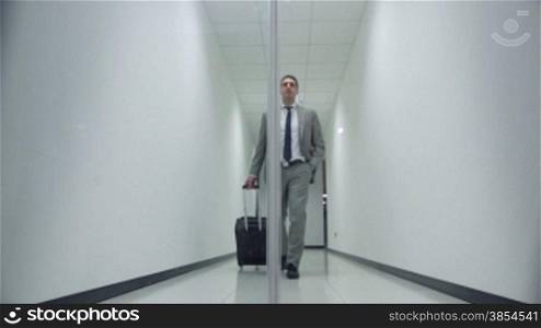 Business man walking with trolley in corridor of office building and passing through automatic door. Sequence, 1of20