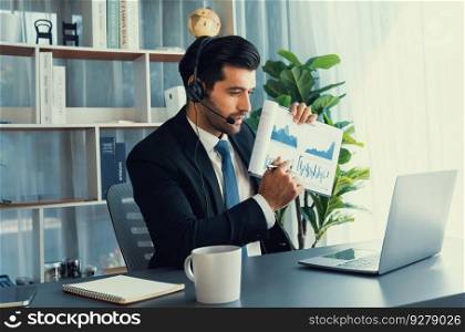 Business man wearing headphone present financial data or BI paper via laptop during online meeting. Remote work concept with virtual meeting presentation of effectiveness remote work. Fervent. Businessman with headphone present BI paper during online meeting. Fervent
