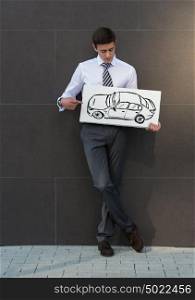 Business man with new car sign. Dealer or buyer showing car sign. Credit concept