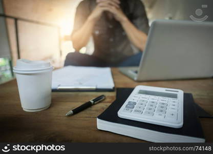 Business man working at a cafe with laptop, finance documents and calculator on the table, selective focus