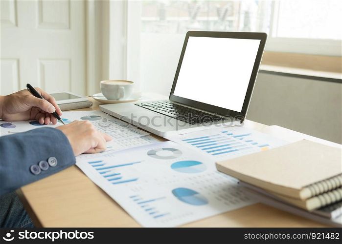 Business man working at office with laptop, and financial graph data documents on his desk.5