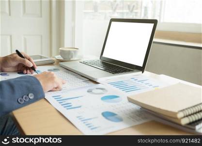 Business man working at office with laptop, and financial graph data documents on his desk.5