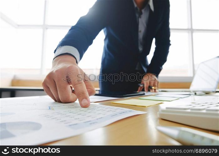 business man working on business documents, calculator and laptop at a workplace