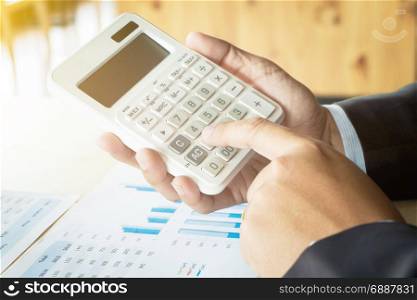 business man working on business documents with calculator