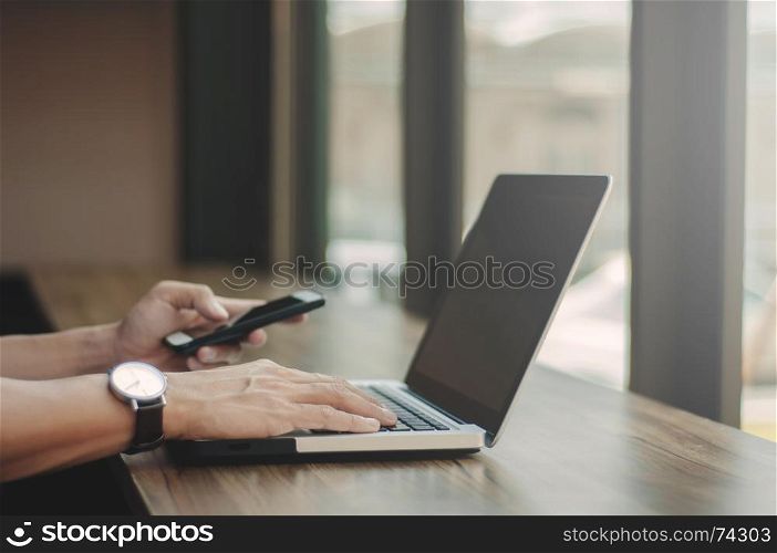 business man working on laptop and using mobile smart phone at workplace