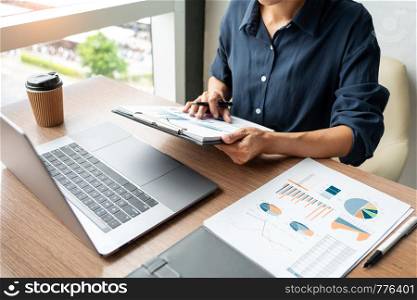 Business man working with graph data in laptop and documents on his desk at office