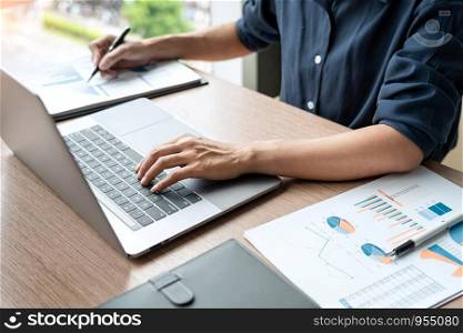 Business man working with graph data in laptop and documents on his desk at office