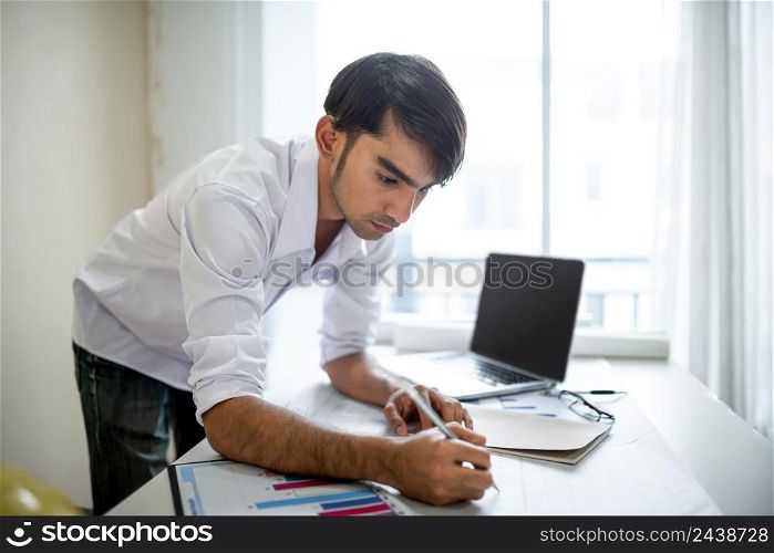 Business man working with laptop and documents on his desk.analyzing data in office