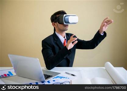 Business man working with laptop and using virtual reality glasses.analyzing data in office