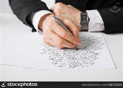 business, marketing, planning and people concept - close up of male hands with pen drawing scheme on white paper