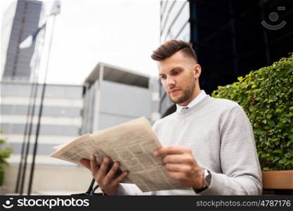 business, mass media and people concept - man reading newspaper on city street bench