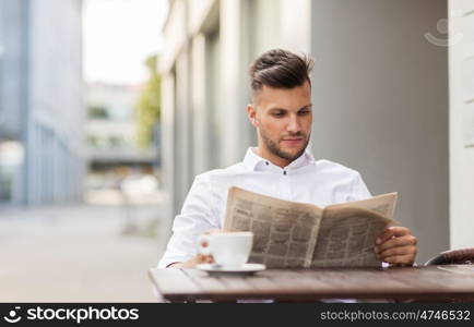 business, mass media and people concept - smiling man reading newspaper with coffee at city street cafe