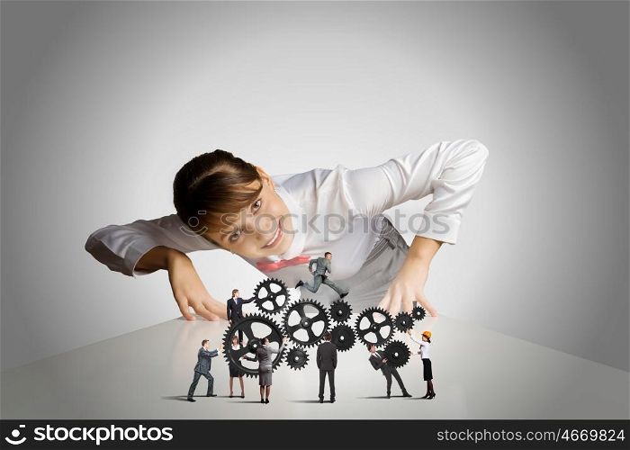 Business mechanisms. Businesswoman leaning on table and looking at businessteam