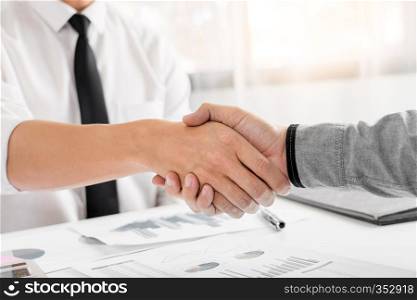 Business Meeting agreement Handshake concept, Hand holding after finishing up dealing project or bargain success at negotiation over office background.