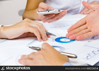 Business meeting. Close up of human hands and documents with graphs and diagrams