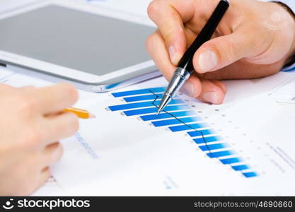 Business meeting. Close up of human hands and documents with graphs and diagrams