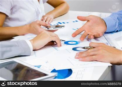 Business meeting. Close up of human hands and documents with graphs and diagrams