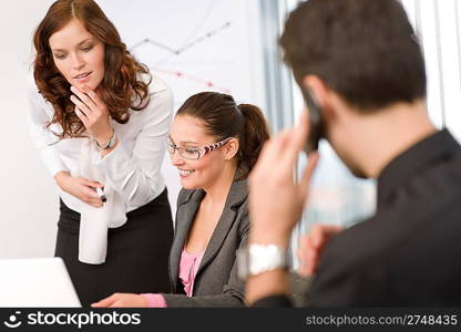 Business meeting - group of people in office sitting at laptop