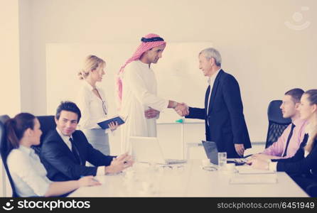 Business meeting - Handsome young Arabic man presenting his ideas to colleagues and listening for ideas for success investments at bright modern office room