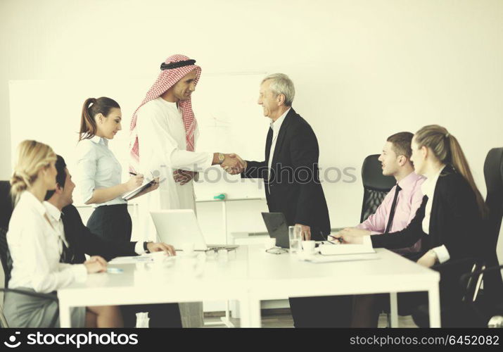 Business meeting - Handsome young Arabic man presenting his ideas to colleagues and listening for ideas for success investments at bright modern office room