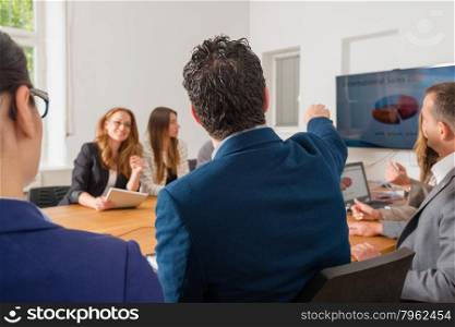 Business meeting in a conference room discussing international sales chart - mixed caucasian team rather casual, ambiente might suggest a startup or an agency