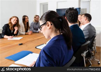 Business meeting in a conference room - mixed caucasian team rather casual, ambiente might suggest a startup or an agency