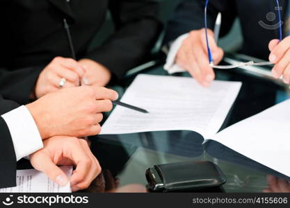 Business - meeting in an office; lawyers or attorneys discussing a document or contract agreement