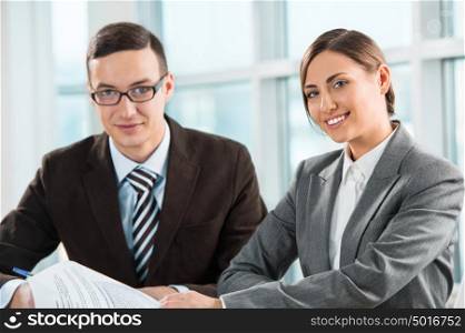 Business meeting in an office - two business people man and woman discussing their plans and reports