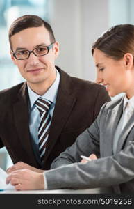 Business meeting in an office - two business people man and woman discussing their plans and reports