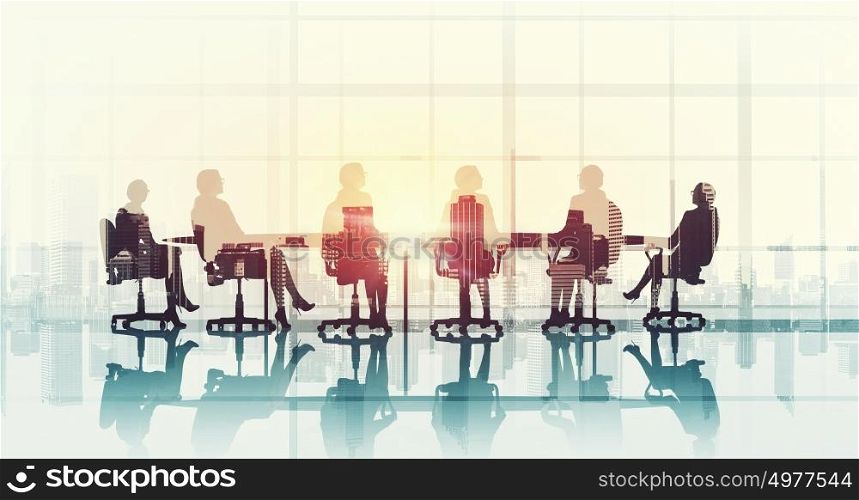 Business meeting in office. Silhouettes of business people sitting at table against office window