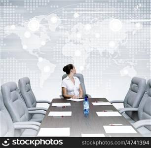 Business meeting. Young attractive businesswoman sitting at head of negotiating table