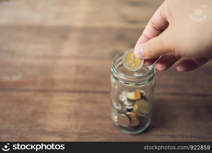 Business men Put the coin in a glass jar To save money, save money on investments, spend money when needed And use in the future. Investment concept. Savings with copy spaces.