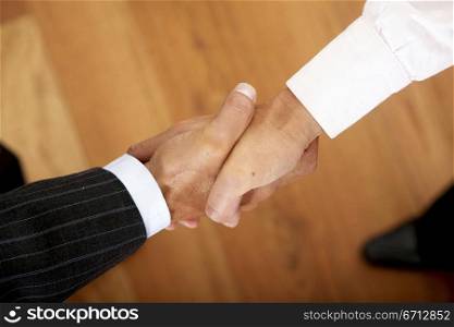 business men sealing a deal in an office with a handshake