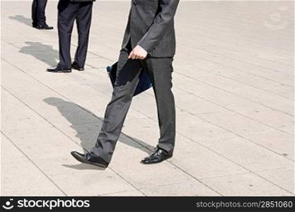 Business men walking on the pavement