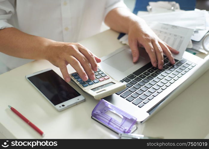 Business men work with calculator and laptop on the white table at office