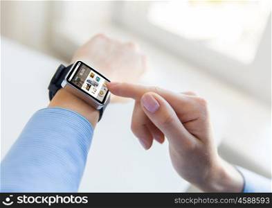 business, modern technology, blogging, media and people concept - close up of female hands setting smart watch with internet blog on screen at office