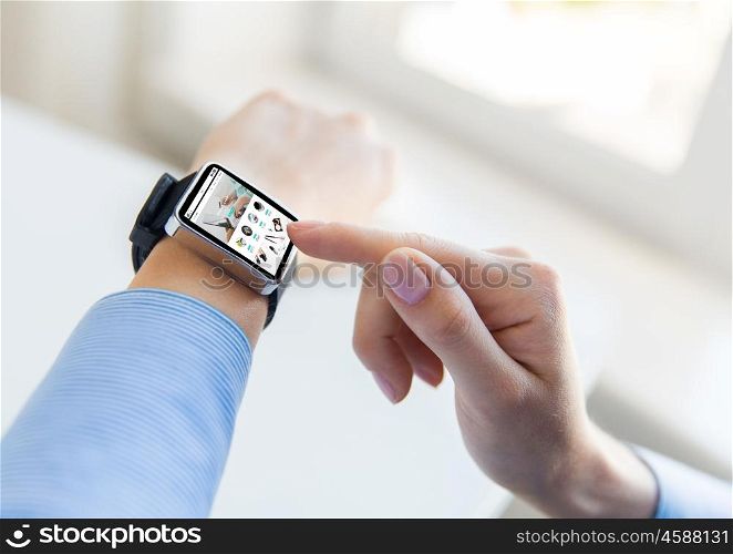 business, modern technology, internet shopping and people concept - close up of female hands setting smart watch with online shop on screen at office