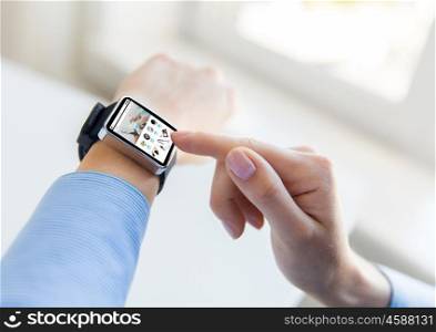 business, modern technology, internet shopping and people concept - close up of female hands setting smart watch with online shop on screen at office