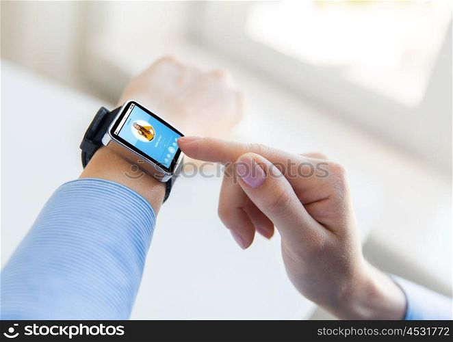 business, modern technology, media and people concept - close up of female hands setting smart watch with music player on screen at office