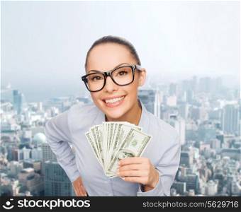 business, money, city and banking concept - smiling businesswoman in eyeglasses with dollar cash money over cityscape background