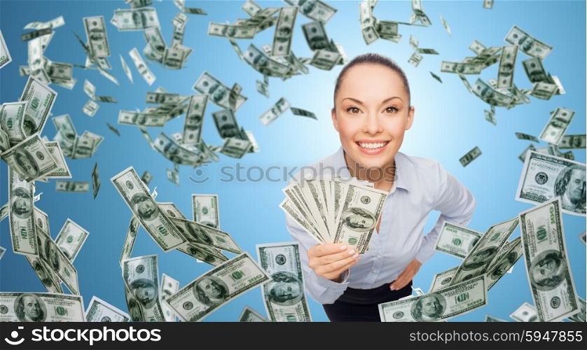 business, money, finance, people and banking concept - smiling businesswoman with heap of dollar cash money over blue background