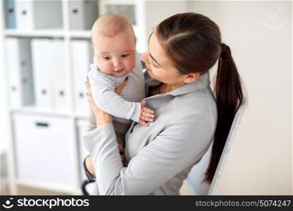 business, motherhood, multi-tasking, family and people concept - happy businesswoman with baby at office. happy businesswoman with baby at office