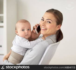 business, motherhood, multi-tasking, family and people concept - happy smiling businesswoman with baby calling on smartphone at office