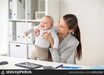 business, motherhood, multi-tasking, family and people concept - happy smiling businesswoman with baby working at office. happy businesswoman with baby working at office