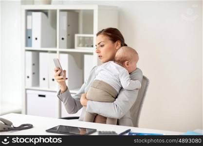 business, motherhood, multi-tasking, family and people concept - smiling businesswoman with baby and smartphone working at office