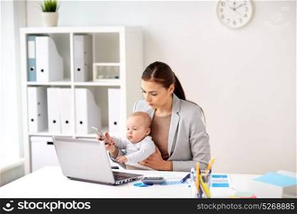 business, motherhood, multi-tasking, family and people concept - smiling businesswoman with baby and smartphone working at office. businesswoman with baby and smartphone at office