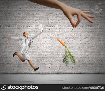 Business motivation. Funny image of businesswoman chased with carrot